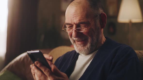 Senior Man with Smartphone Laughing alt