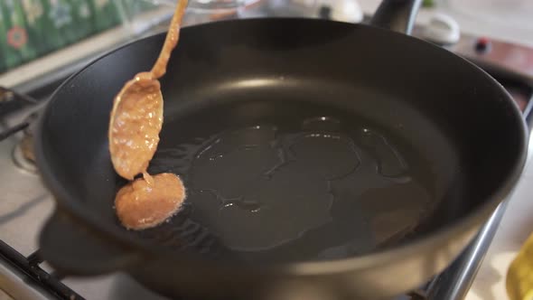 Woman Roasts Liver in a Frying Pan