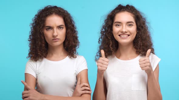 Two Beautiful Female Twins with Curly Hair Standing on Blue Background alt