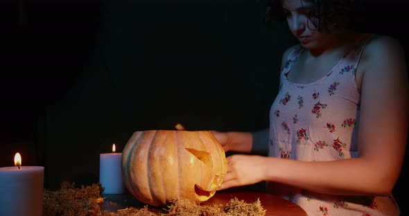 Woman Carving A Pumpkin in the dark