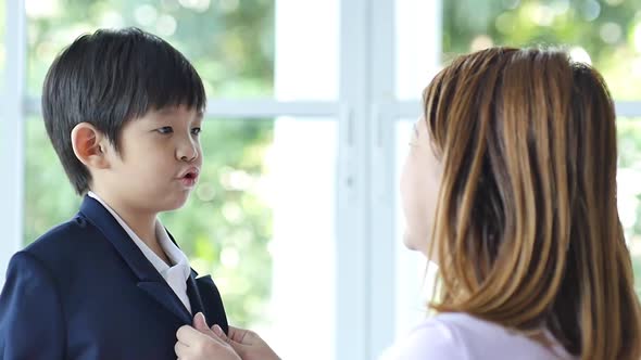 Asian mother  saying goodbye to her son as he leave for School,back to school concept alt