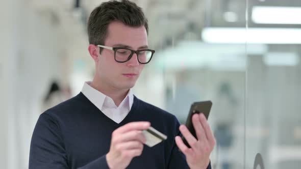Young Businessman Making Online Payment on Smartphone  alt