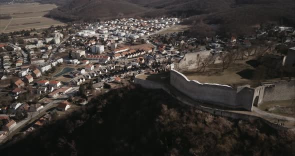 Flying above old castle on Hill in Hainburg and revealing urban area, Aerial shot, Austria alt