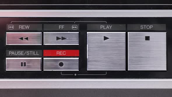 Extreme close up of buttons on an old antique or vintage VCR pushing Record alt