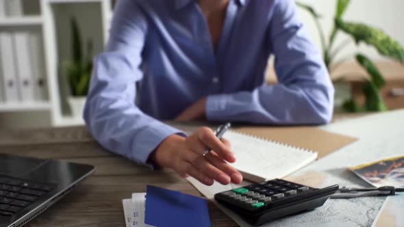 Working On A Calculator, The Manager Counts The Finance Figures While Sitting In The Tourist Office alt