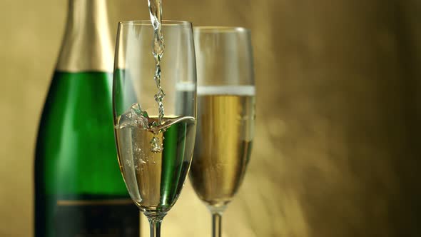 Super Slow Motion Shot of Pouring Champagne on Golden Luxury Background at 1000Fps alt