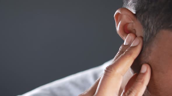 Young Man Having Ear Pain Touching His Painful Ear  alt