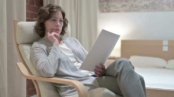 Hardworking Old Woman Reading Documents on Sofa alt