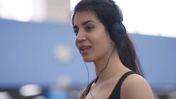 Closeup Portrait of Charming Beautiful Middle Eastern Sportswoman Enjoying Music in Headphones alt