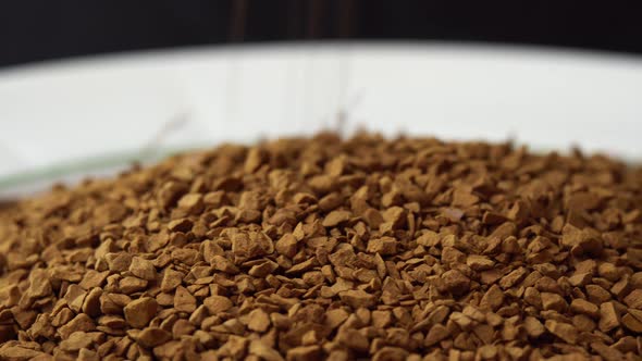 Granules of Instant Coffee Sprinkled on a Plate Closeup Spinning As a Backdground for a Coffee Shop alt