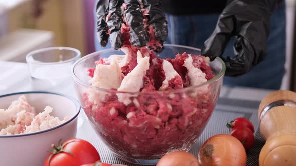 Kneading of Minced Meat with Onion and Spices in a Glass Bowl alt