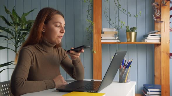 Businesswoman Sitting at Workplace Desk, Hold Smartphone and Call Up with Colleague on Speakerphone alt