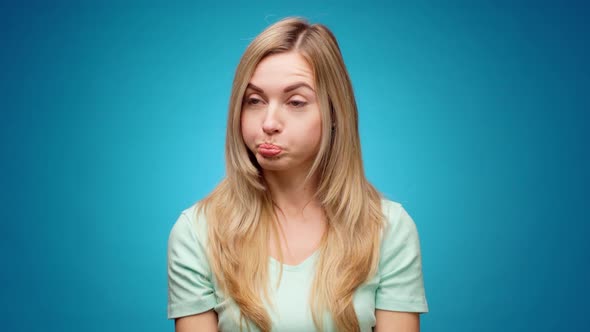 Thoughtful Woman Looking Aside with Pensive Expression Againast Blue Background alt