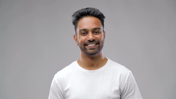 Young Laughing Indian Man Over Gray Background 14 alt