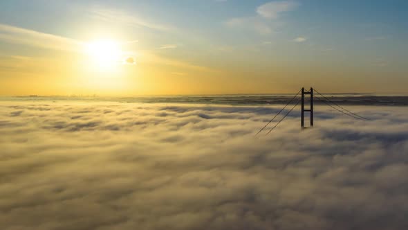 Aerial reveal of the Humber Bridge as the sun is rising with low cloud and fog passing by very quick alt