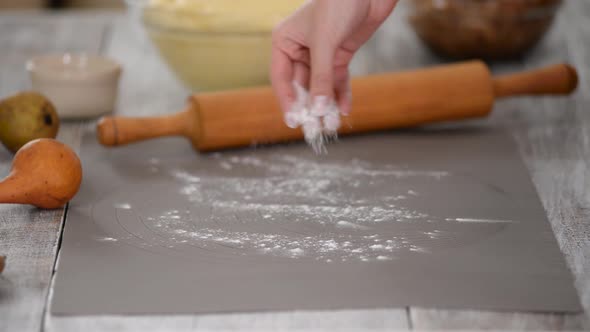 Women's Hands Put the Dough Out of a Glass Bowl on the Table in the Home Kitchen