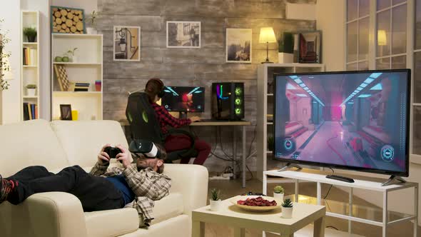 Man Lying on Sofa Playing Video Games Using Vr Headset alt