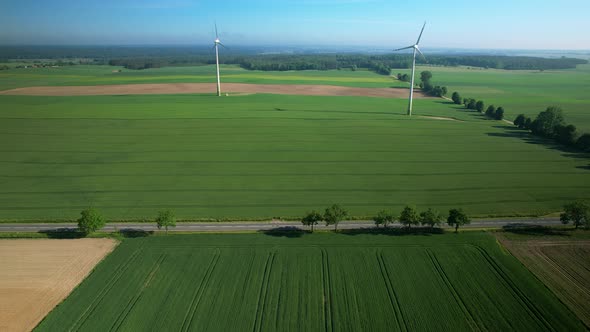 Windmills over fields, aerial drone pull out. Beautiful. alt