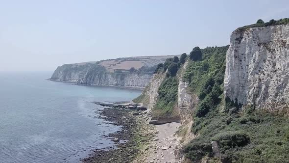 Rocky cliff along the Jurassic Coastline in Seaton, United Kingdom. The forest covered cliffs drops alt
