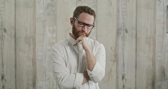 Pensive Guy Leaning Hand Rubbing Beard While Thinking Over Difficult Choice