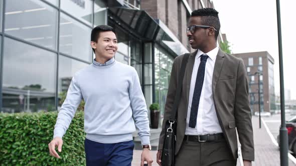 Two Male Colleagues Walking Together on Street alt
