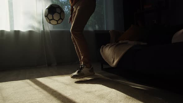 Man Professional Football Player Training and Controlling a Soccer Ball in the Living Room at Home alt