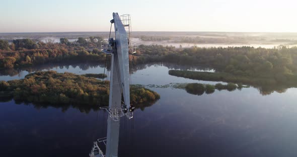 Boom of an Idle Port Crane on the Background of the River at Dawn alt