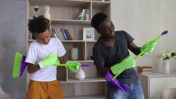 Afro American Mixed Son and Dad Cleaning the House and Pretending to Be Playing Guitar Spbi alt