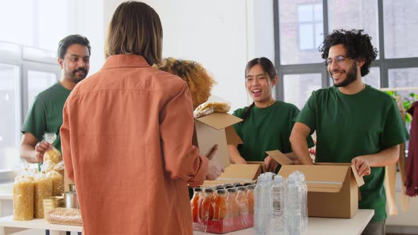 Happy Volunteers Packing Food in Donation Boxes alt