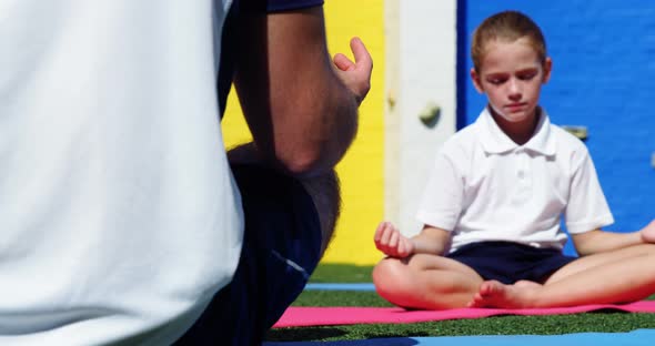 Yoga instructor instructing children in performing yoga alt