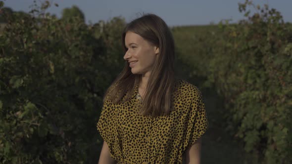 Woman Looking At Camera And Smiling At Vineyard