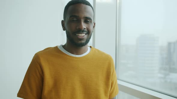 Slow Motion Portrait of Young African American Man Smiling at Home Near the Window alt