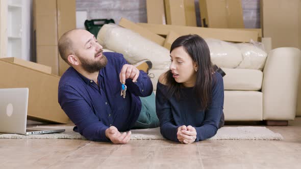 Couple Laying Down on the Floor of Their New Apartment alt