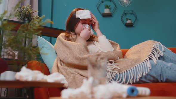 Portrait of Young Woman Suffering From Cold or Allergy in Plaid Lying on Sofa in Living Room at Home alt