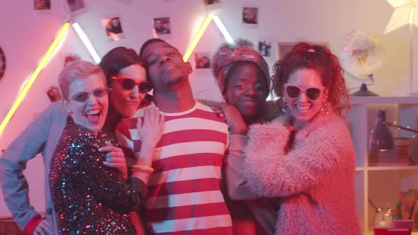 Young Black Macho Surrounded by Pretty Women Posing for Camera at Home Party alt