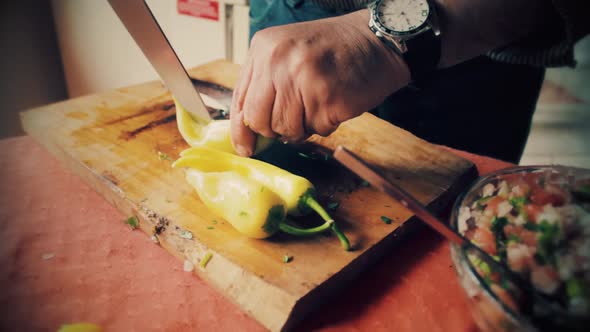 Cutting green pepper on a old style the cutting board to make a chilean organic salad alt