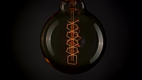 Luminous Element of Edison's Lamp Lighting Up Gradually in the Dark and Going Down.  alt