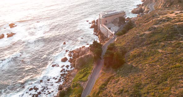 Aerial orbit of the coast of concon in a sunset highlighting the waves and vegetation. alt