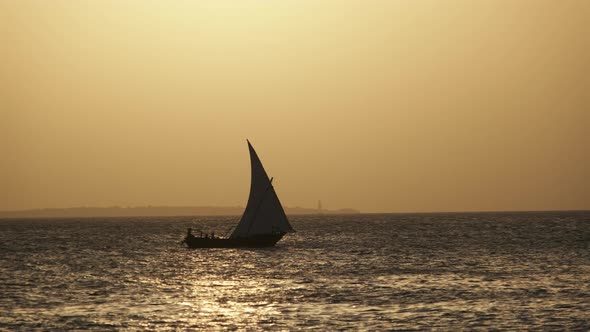 Silhouette African Wooden Dhow Boat Sailing By Ocean at Sunset Zanzibar Africa alt