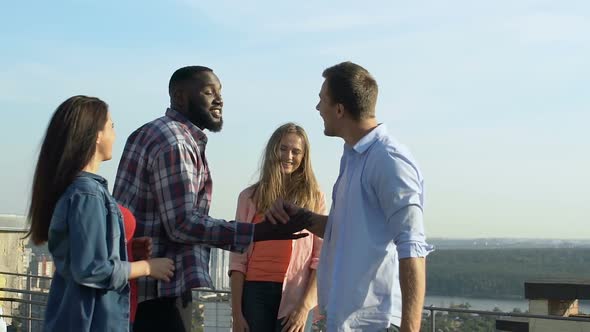 Young Men and Women Joking and Laughing at Roof Party, Having Fun Together