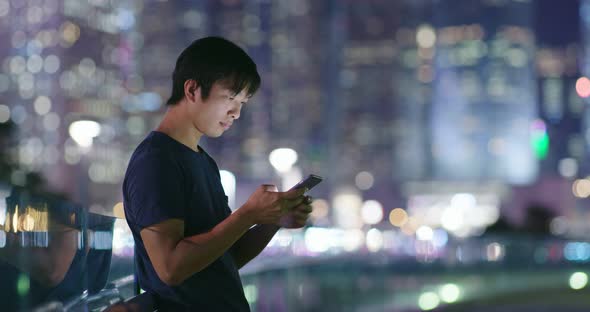 Man use of mobile phone in city at night alt