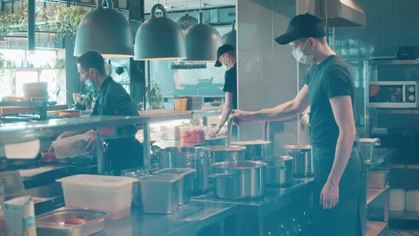 Restaurant Personnel are Cooking Food in Face Masks alt