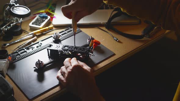 Man Assemble FPV Drone on Workbench at Home