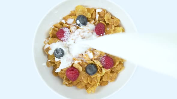 Corn Flakes With Raspberry In A Bowl Pouring With Milk