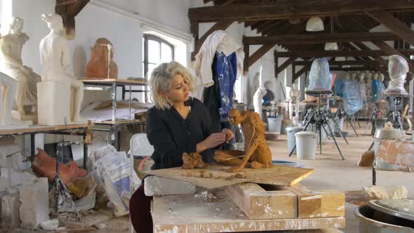 Sculptor is Sculpting a Realistic, Figurative Model in Large Studio
