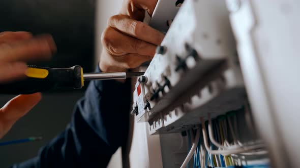 An Electrician Assembles an Electrical Panel in an Apartment alt
