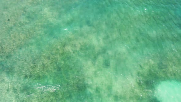 Flight over the sea beach yellow sand is replaced blue turquoise ocean water 