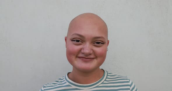 Bald girl posing and smiling in front of camera - Real people, diversity and female power concept alt