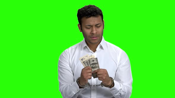 Confused Handcuffed Businessman Holding Money alt