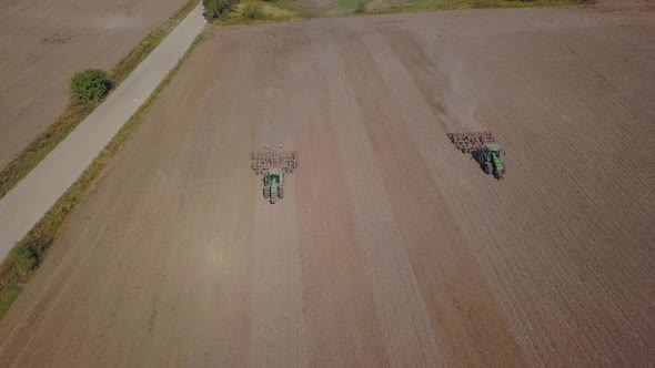 Aerial View. Tractor Cultivates Agricultural Land.